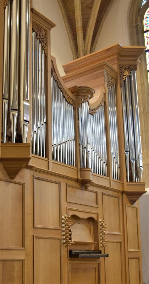 Illustratie van muziekinstrumenten in een kerkelijke setting, zoals een orgel, harp en violen.